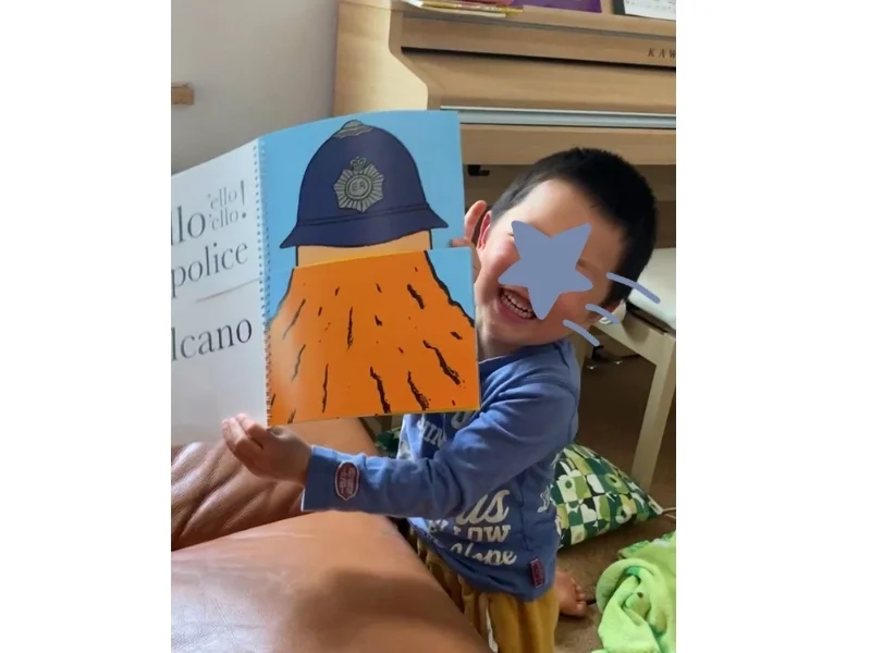 お子さんが絵本を開いて笑っている様子